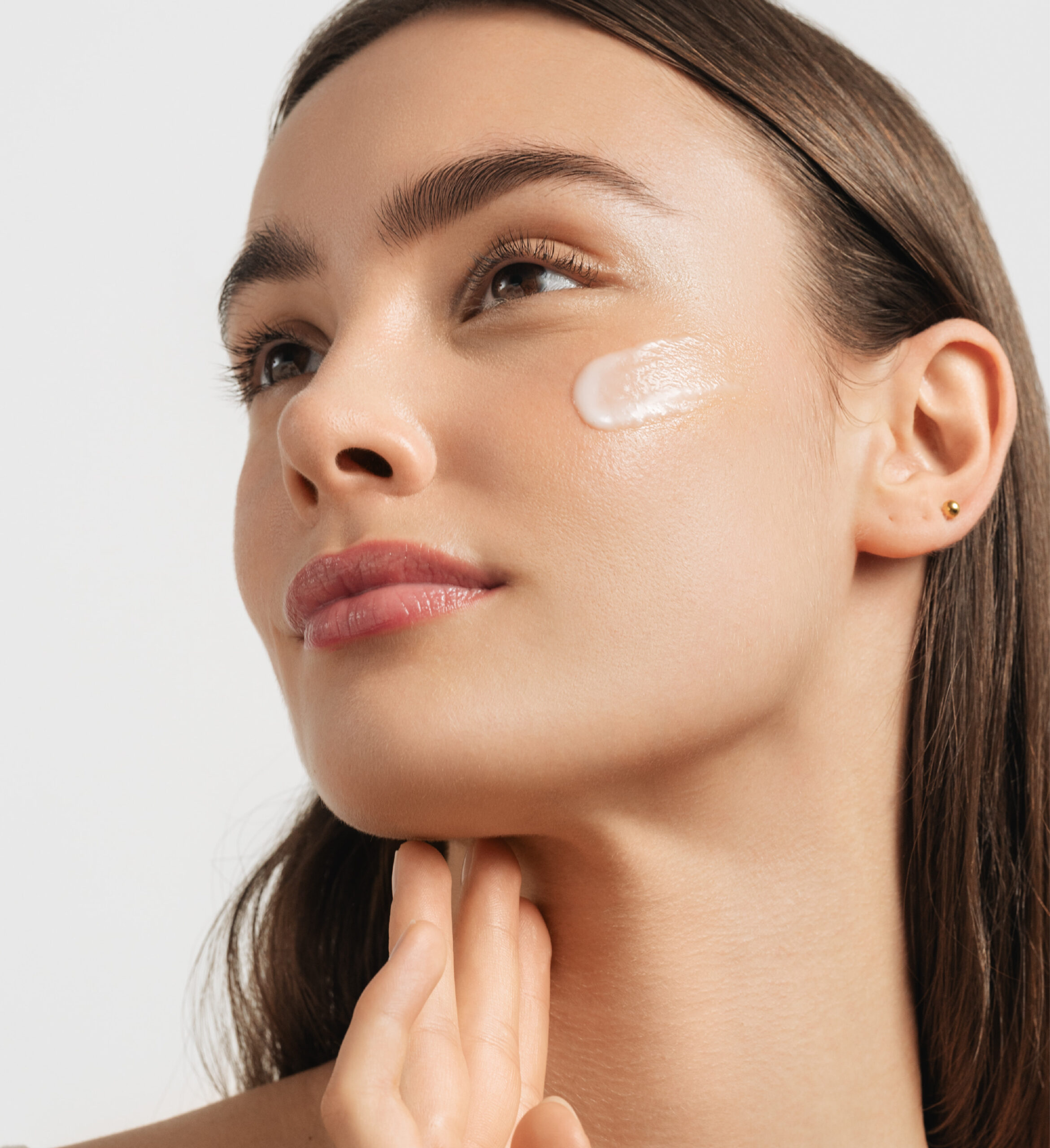 Model applying Innovyal cream on cheek